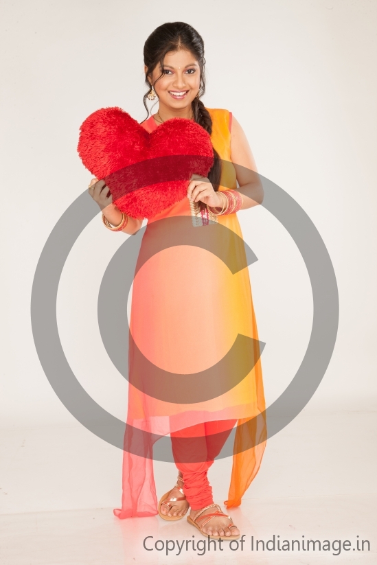 Girl posing with a heart shaped pillow